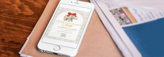 Laptop on a desk displaying a holiday digital invitation template with festive décor around it.